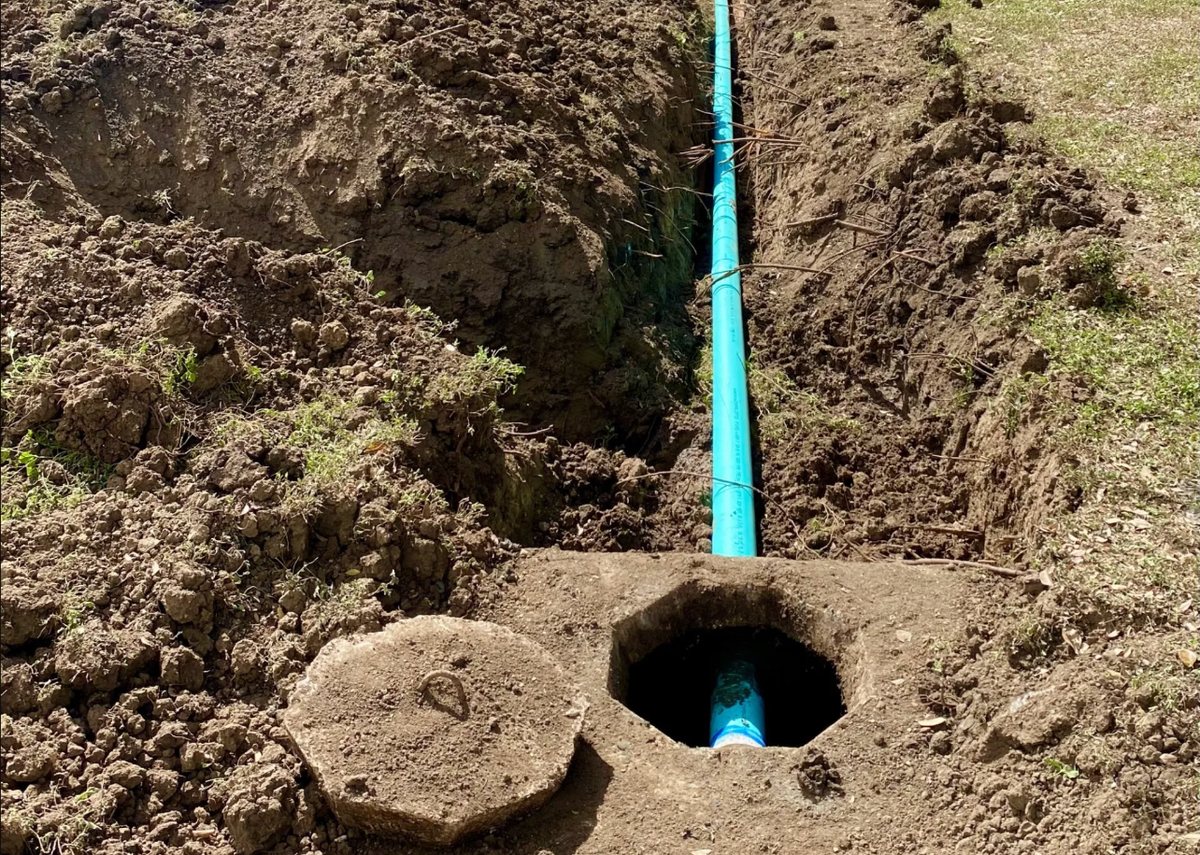 Outlet line running to a septic tank with the lid lifted