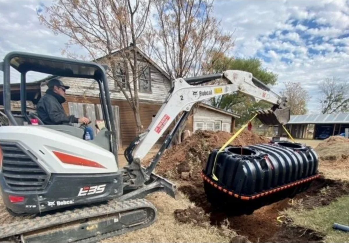 Mini excavator setting a new poly septic tank